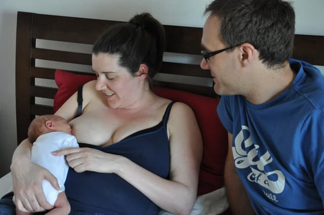Mum feeding a baby with Dad supporting