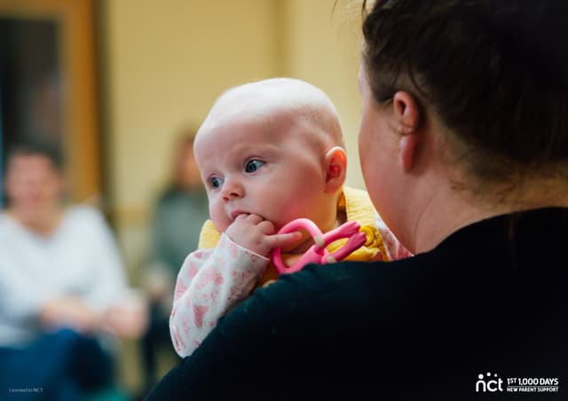 Baby looking over Mum's shoulder