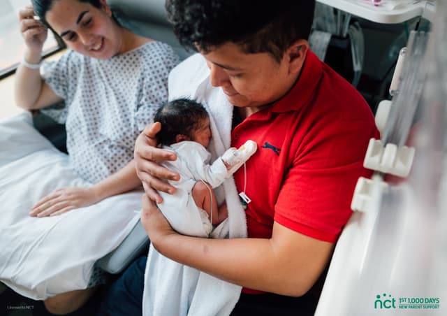 Dad holding baby in hospital